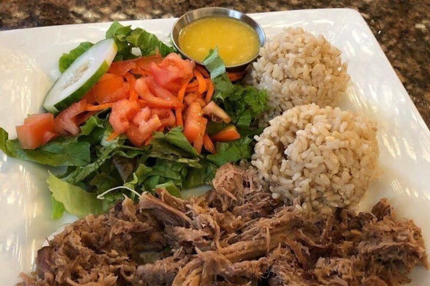 Une assiette contenant de la viande effilochée, du riz, une salade et un petit bol de sauce. 5