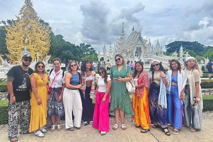 Un groupe de personnes se tient devant un grand bâtiment orné, dont l’architecture est riche et complexe. 5