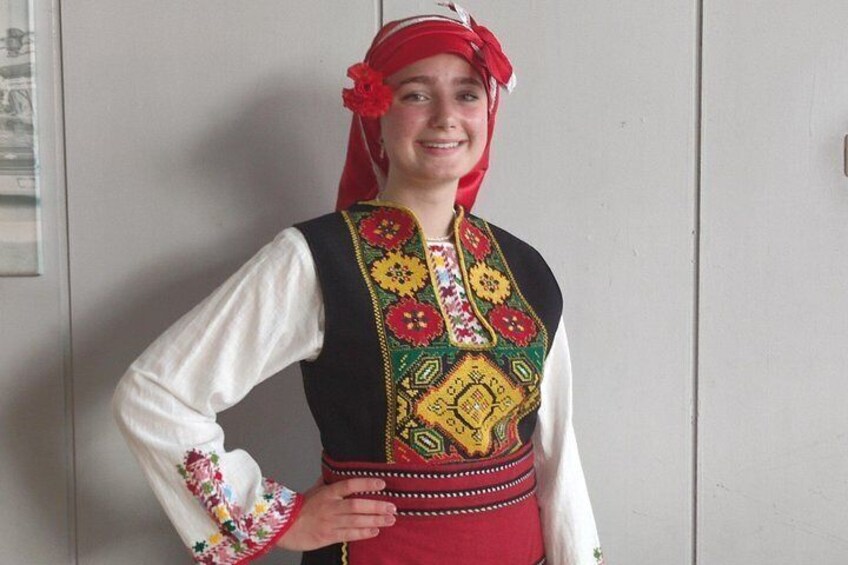 A person wearing a traditional embroidered vest with floral patterns. 2