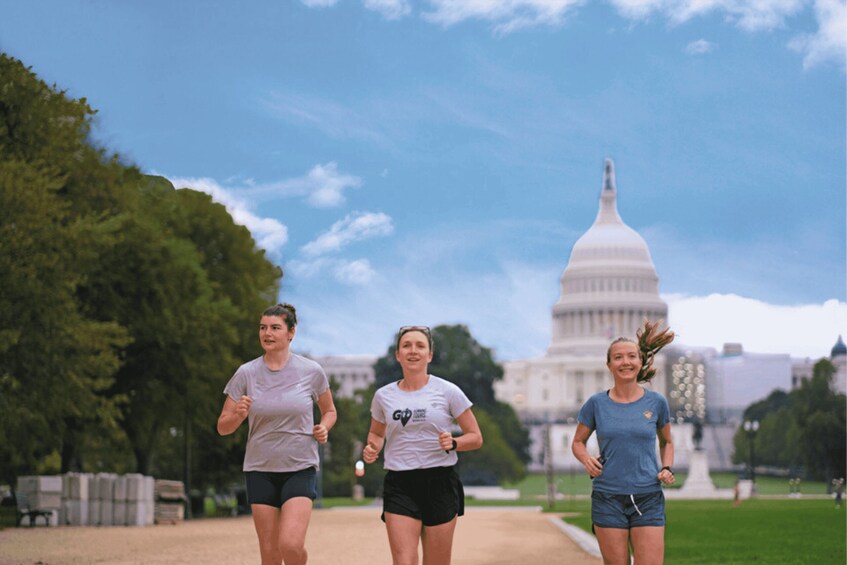 Three people jogging on a path with the United States Capitol building in the background. 1