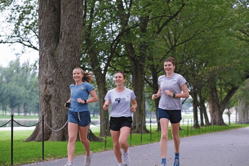 Three people jogging on a tree-lined path. 3