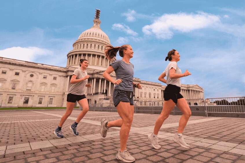Three people jogging in front of a large government building. 2