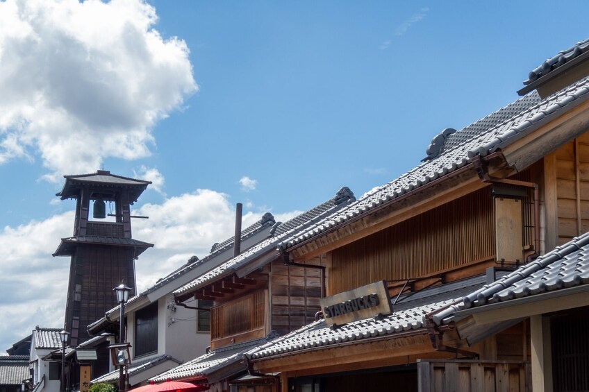 Traditionel japansk arkitektur med et markant tårn og et Starbucks skilt. 2