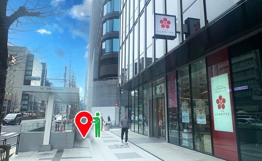A modern urban street with glass-fronted buildings, a pedestrian crossing, and a bus stop shelter. 2