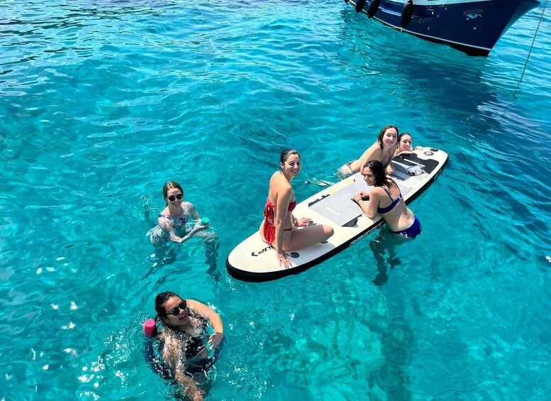 A group of people on a floating platform in clear blue water. 5
