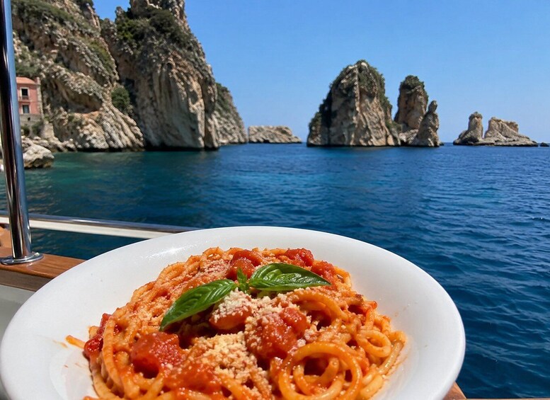 A plate of spaghetti with tomato sauce and basil, set against a backdrop of rocky cliffs and the sea. 2