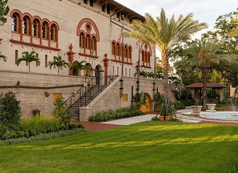 A historic building with arched windows, a staircase, and a fountain. 1