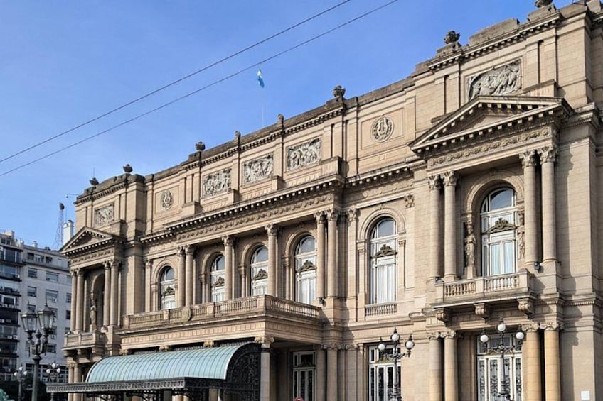 Un bâtiment historique à l’architecture classique, caractérisé par des fenêtres en arc et des moulures décoratives. 3