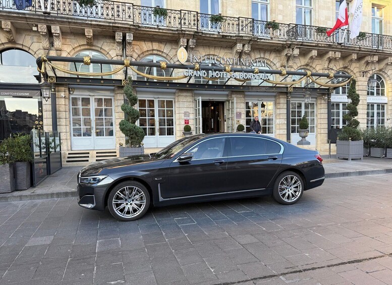 A black luxury car parked in front of the Intercontinental Grand Hotel de Bordeaux. 2