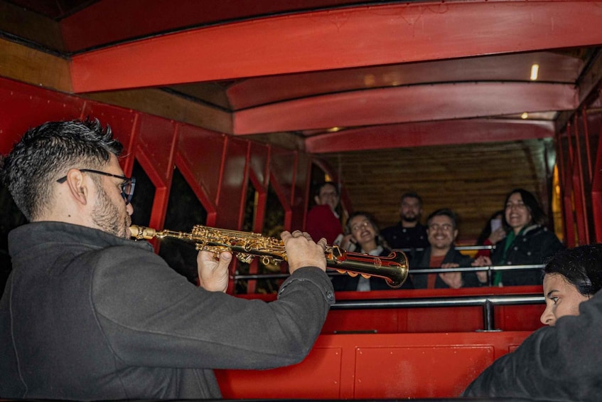A person playing a brass instrument inside a red vehicle. 5