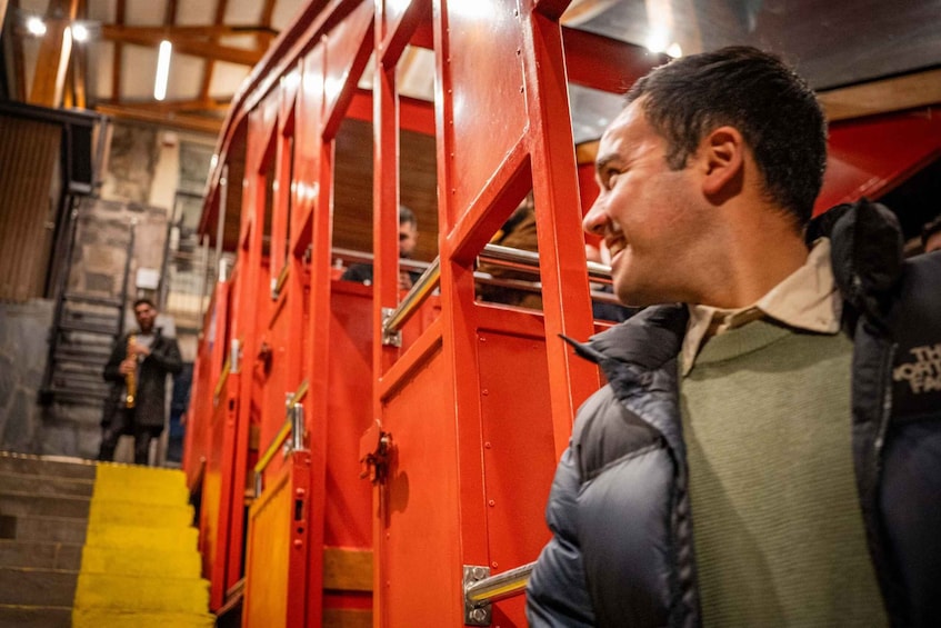 A person standing next to a red fire truck with yellow steps leading up to it. 2