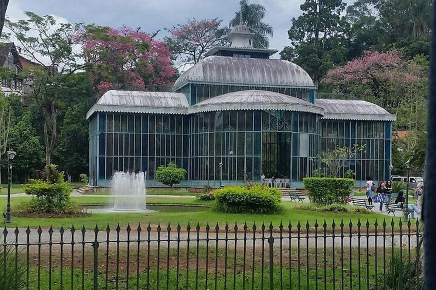 Une véranda avec une fontaine, entourée d’une clôture et de verdure. 4