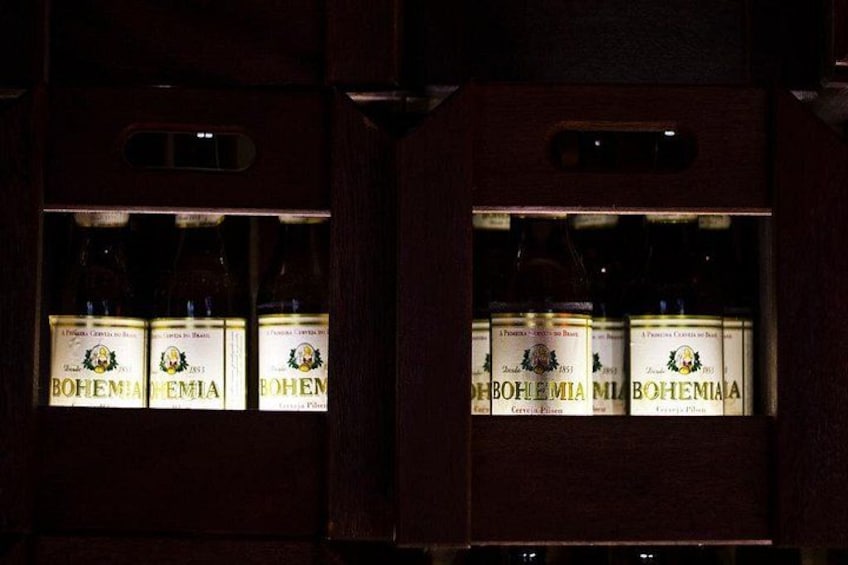 A wooden cabinet with bottles of Bohemia beer. 2