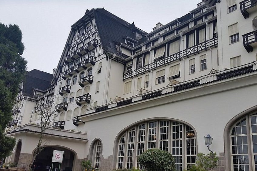 A historic building with a steeply pitched roof, multiple balconies, and large arched windows. 5