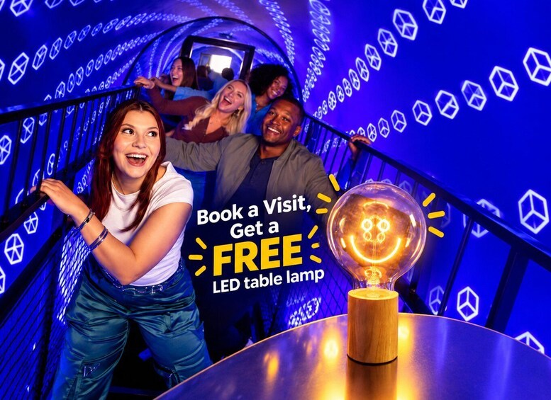 A promotional event with people in a tunnel-like structure with LED lights, and a table lamp on display. 1