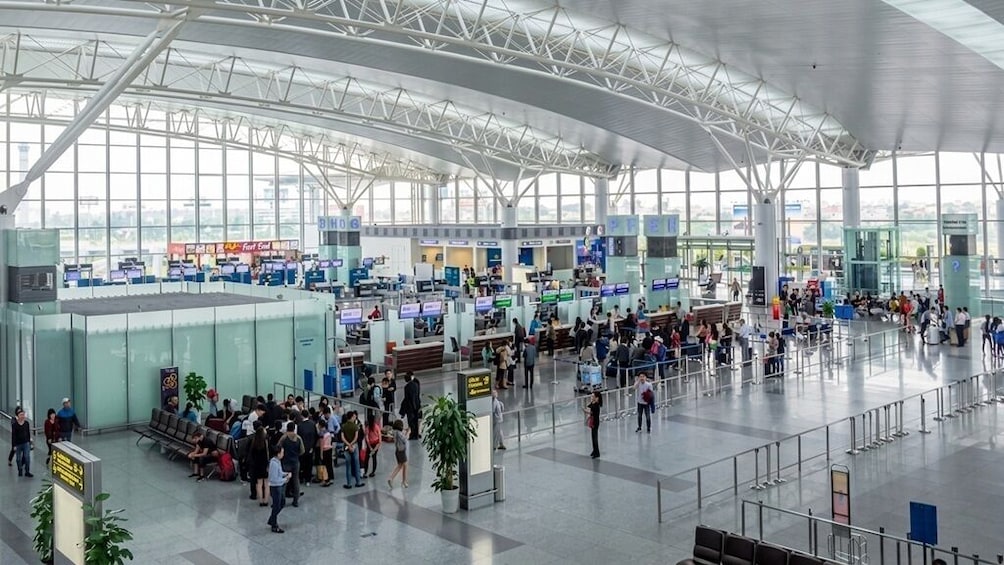 Un vaste terminal d’aéroport doté de nombreux comptoirs d’enregistrement et de plusieurs espaces d’attente. 5