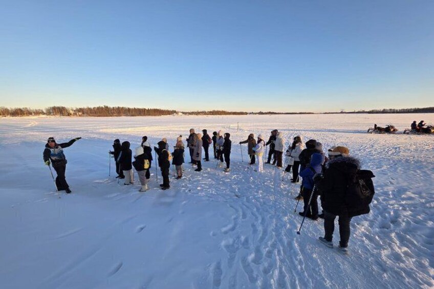 Een groep mensen op ski's in een besneeuwd veld onder een heldere hemel. 2