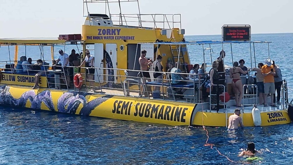 A yellow semi-submarine with people on board and some in the water. 5