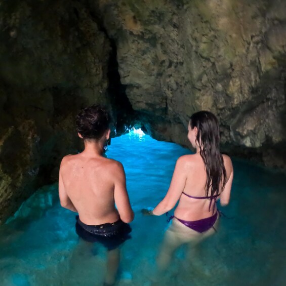 Two people in a cave with a pool of water. 3