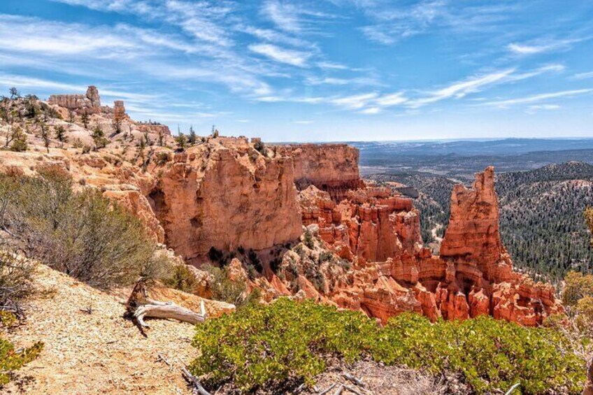 A rugged landscape with prominent red rock formations and sparse vegetation. 4