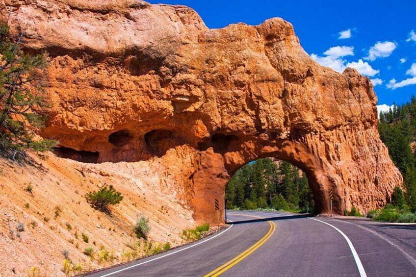 Una carretera que atraviesa una formación rocosa en arco natural. 2