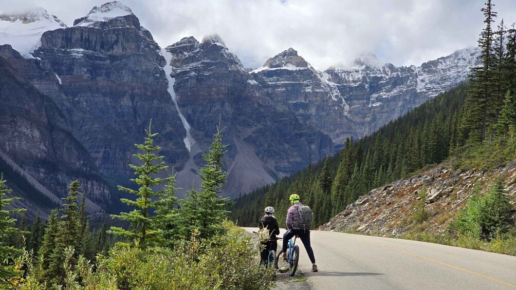 A mountain road with cyclists and a waterfall in the background. 4