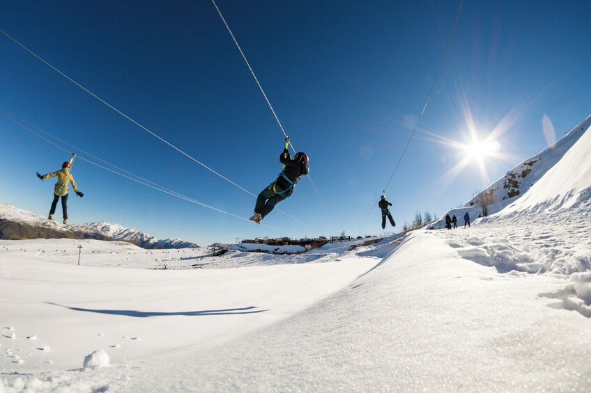 A person skydiving in a snowy landscape with mountains in the background. 4
