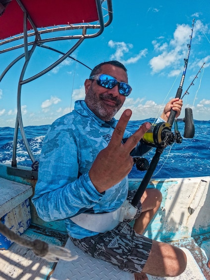 A person on a boat holding a fishing rod. 2