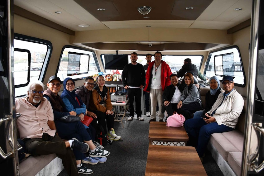 A group of people inside a vehicle with a table and snacks. 5