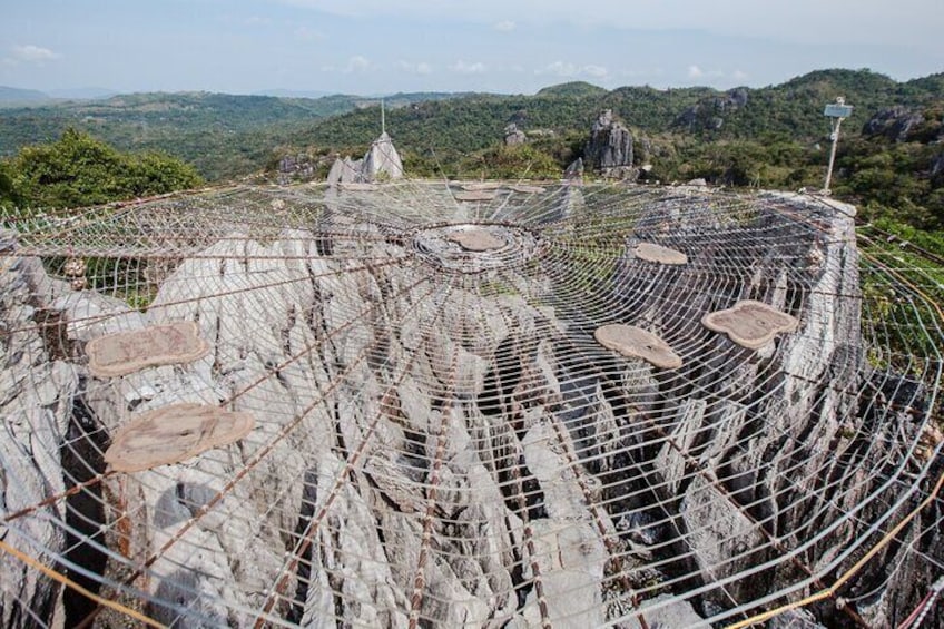 A large, circular stone structure with a wire mesh fence, surrounded by a mountainous landscape. 4