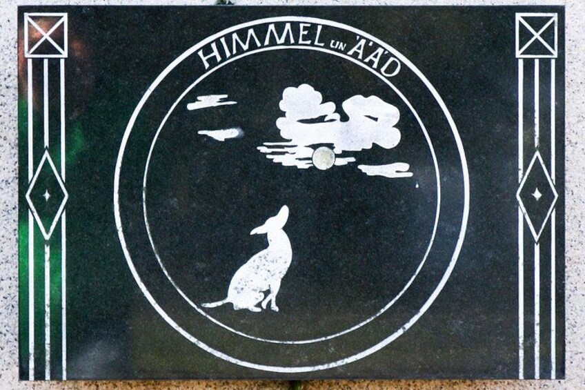A circular emblem with a kangaroo silhouette, clouds, and the text 'HIMMEL UN A'ADO'. 2