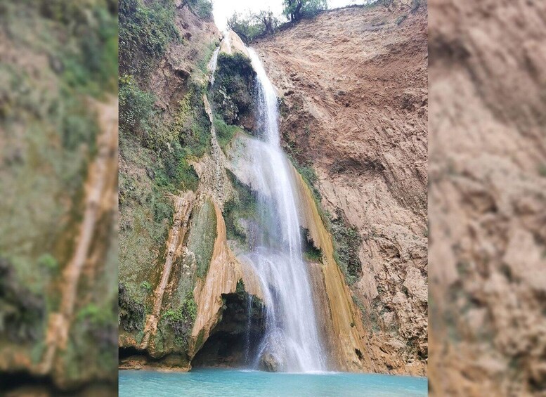 A waterfall cascading into a turquoise pool surrounded by rocky cliffs. 2