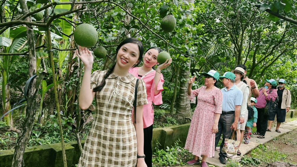 A group of people standing on a path surrounded by lush greenery and trees. 5