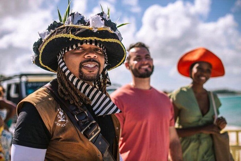 A person in a pirate costume with a hat and vest, a man in a red shirt, and a woman in a green dress with an orange hat. 2