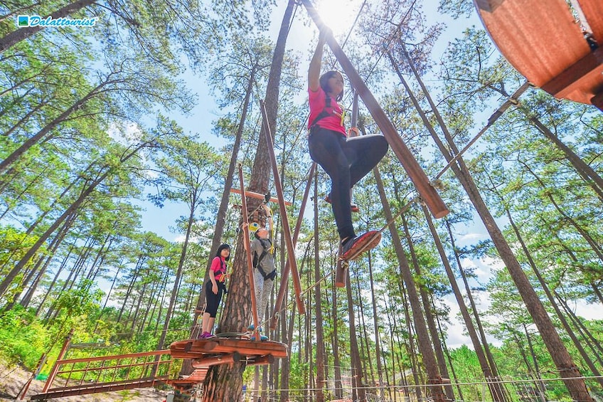 Henkilö kiipeää puiseen rakennelmaan metsässä. 4