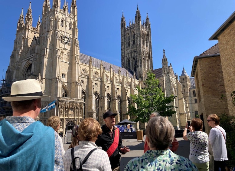 A group of people standing in front of a large Gothic cathedral with intricate architecture. 1