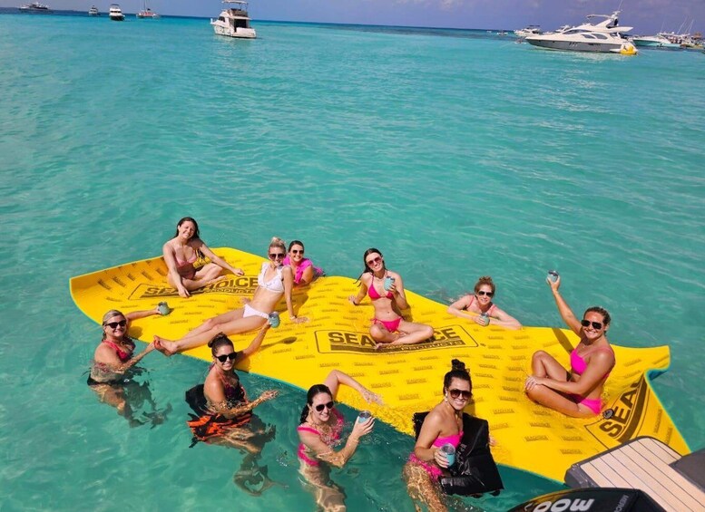 A group of people on a yellow inflatable raft in clear turquoise water. 5