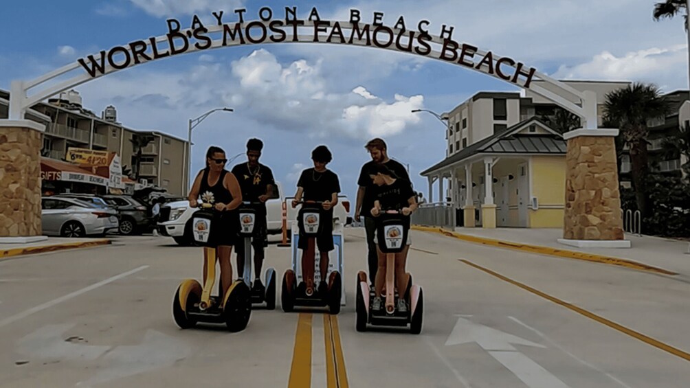 A group of people on segways at Daytona Beach's famous entrance. 3