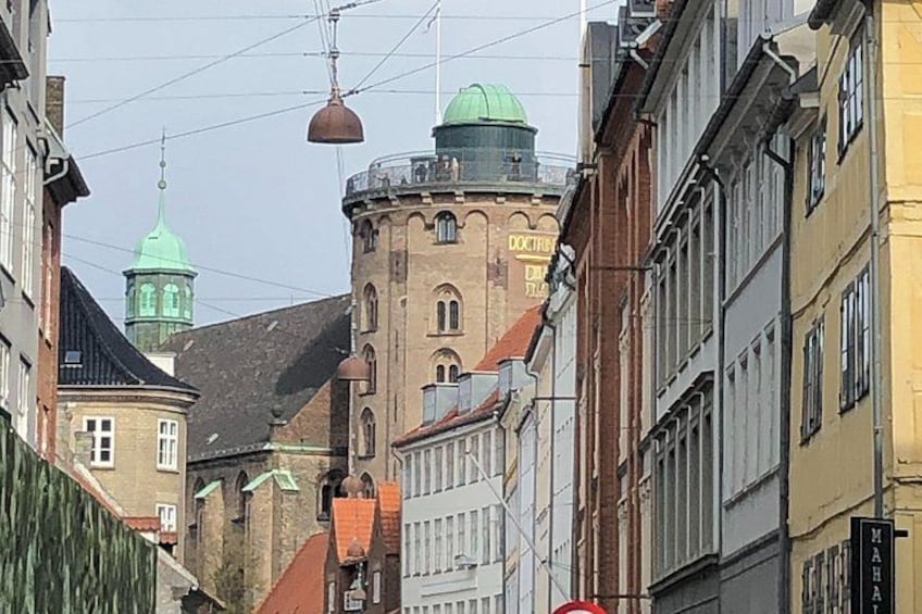 A street with historic buildings, a tower with a green dome, and a sign reading 'DOCTHR'. 3