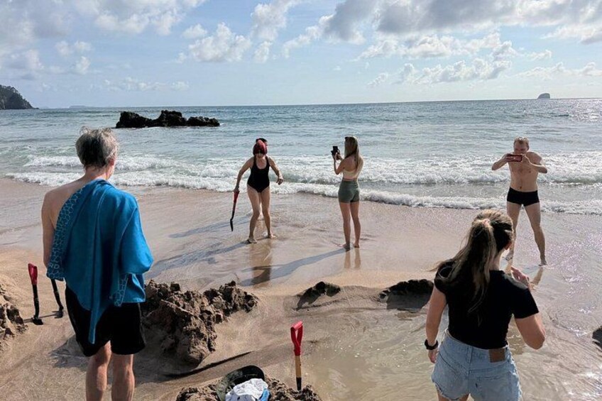 A beach scene with people, some in swimsuits, and a photographer. 2