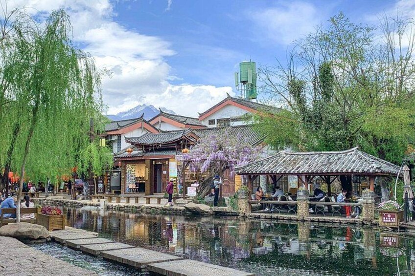 A traditional Chinese courtyard with a pond, willow trees, and a pavilion. 4