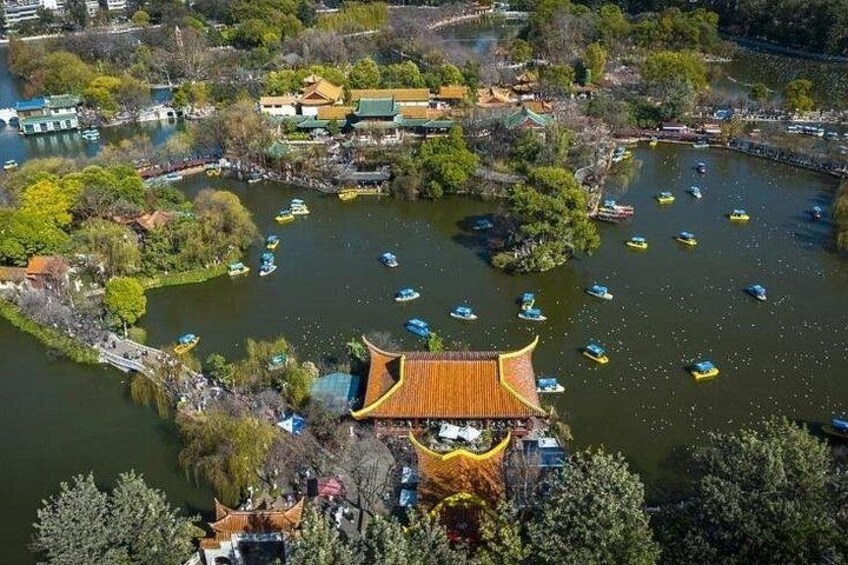 A traditional Chinese pavilion by a lake with boats. 1