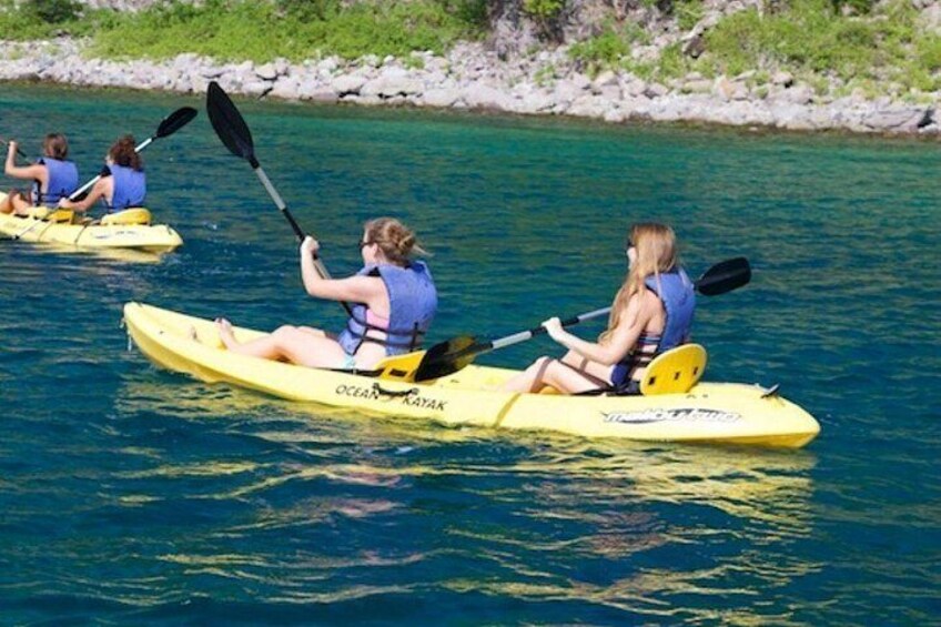 People kayaking on a calm body of water. 2