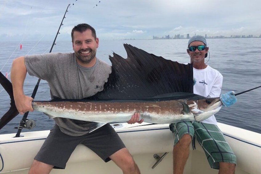 Zwei Personen in einem Boot halten einen großen Fisch. 2