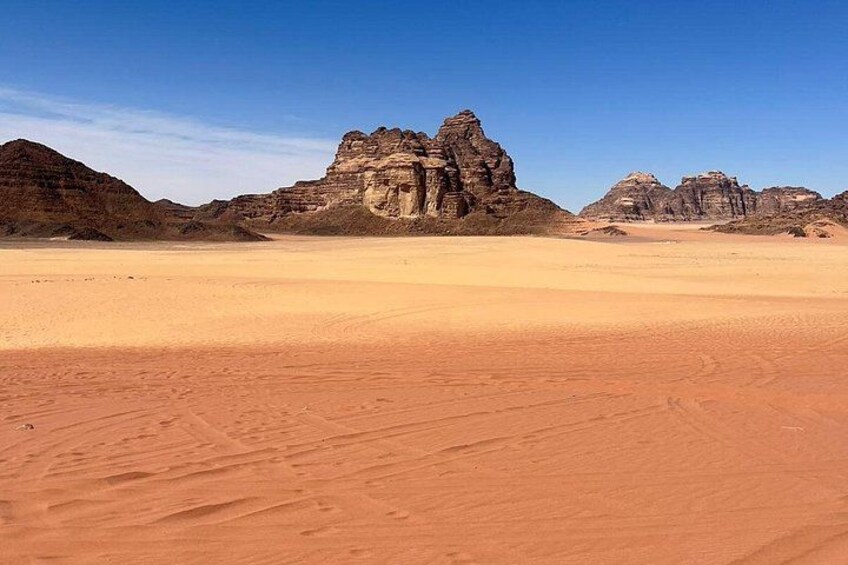 A desert landscape with prominent rock formations and a clear sky. 4