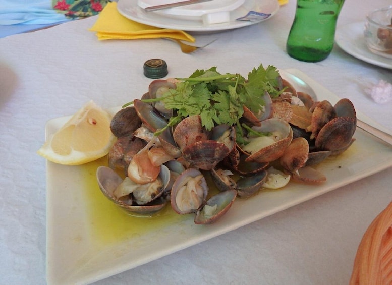 A plate of clams garnished with lemon and parsley. 4