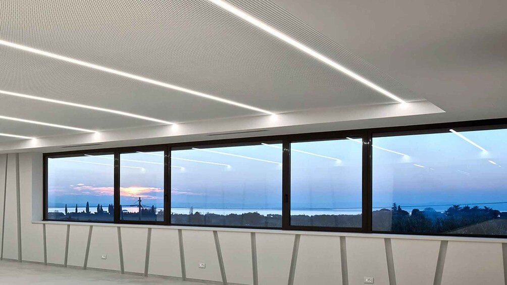 A modern interior with large windows overlooking a landscape. 3