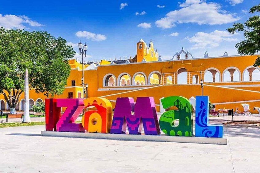 Colorful letters spelling 'ZAMBLE' in a plaza with a yellow building in the background. 5