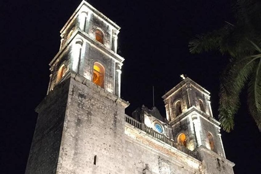 A historic tower with illuminated windows and a clock, set against a night sky. 2