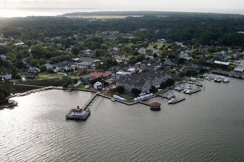 A coastal town with a dock, boats, and houses. 2